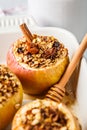 Baked apples with granola, cranberries, nuts and honey in oven dish Royalty Free Stock Photo