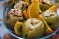 Baked apples with toppings and chopped oranges