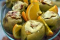 Baked apples with toppings and chopped oranges