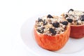 Baked apples with walnuts, raisins on a plate on a white background