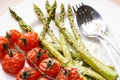 Baked asparagus and cherry tomatoes in a plate, close-up