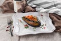 Baked aubergine stuffed with tomatoes and vegetables in sauce on the table Royalty Free Stock Photo