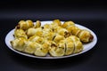 Baked ausages in the dough on a white plate against black background. Sausage Puff Pastry Buns.sausages wrapped in puff pastry and Royalty Free Stock Photo