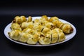 Baked ausages in the dough on a white plate against black background. Sausage Puff Pastry Buns.sausages wrapped in puff pastry and