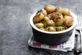 Baked baby potatoes with spices in a bowl on gray stone table