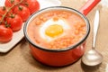 Baked beans with fried egg in a red enamel pot Royalty Free Stock Photo