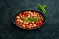 Baked beans in tomato sauce on a black stone plate. Royalty Free Stock Photo