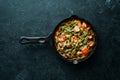 Baked beef with beans, tomatoes and vegetables in a frying pan. Top view. Royalty Free Stock Photo