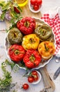 Baked bell peppers stuffed. Mushrooms, rice, cheese and herbs stuffed peppers in a baking dish on a white wooden table. Royalty Free Stock Photo