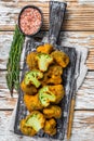 Baked Breaded broccoli on a wooden board with herbs. White wooden background. Top view