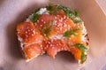 Baked bun with fresh cream, garnished with smoked fish trout and sprinkled with fresh dill and sesame seeds, close-up