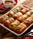 Baked cabbage rolls stuffed with groats and mushrooms in tomato sauce in a casserole dish Royalty Free Stock Photo