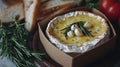 close up of baked brie cheese with garlic and rosemary, served with sliced bread and tomatoes, a culinary delight for cheese lover Royalty Free Stock Photo