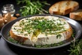 Baked Camembert cheese with spices, herbs, sauce and baguette