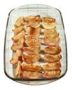 Baked, caramel apple slices in clear glass baking dish