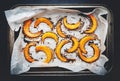 Baked caramelized pumpkin slices on parchment paper, autumn food. Rustic style. Top view