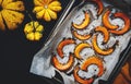 Baked caramelized pumpkin slices on parchment paper, autumn food. Rustic style. Top view