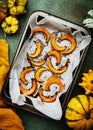 Baked caramelized pumpkin slices on parchment paper, autumn food. Rustic style. Top view