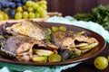 Baked carp with grapes and herbs on a ceramic bowl