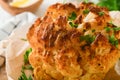 Baked cauliflower. Oven or whole baked cauliflower spices and herbs server on wooden rustic board on old white wooden background t