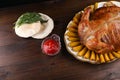 Baked chicken, baked potatoes, bread and sauce on a wooden background. Royalty Free Stock Photo