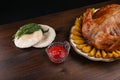 Baked chicken, baked potatoes, bread and sauce on a wooden background. grilled chicken on a dish on a wooden surface Royalty Free Stock Photo