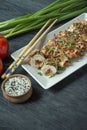 Baked chicken breast rolls with herbs, slices of carrots, bell pepper on a dark cutting board. Asian style. The balance of healthy Royalty Free Stock Photo