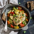 Baked chicken breast with vegetables in a vintage pan on a dark wood surface. Royalty Free Stock Photo