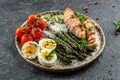 Baked chicken breast wrapped in bacon with asparagus, eggs and cherry tomato, Healthy fats, clean eating for weight loss. Keto Royalty Free Stock Photo