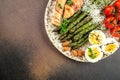 Baked chicken breast wrapped in bacon with asparagus, eggs and cherry tomato, Healthy fats, clean eating for weight loss. Keto Royalty Free Stock Photo