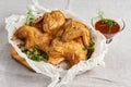 Baked chicken with a crispy crust on a gray fabric background with greenery decor