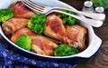 Baked chicken drumstick with organic broccoli on a wooden background. Royalty Free Stock Photo