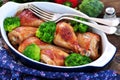 Baked chicken drumstick with organic broccoli on a wooden background. Royalty Free Stock Photo