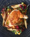 Baked chicken with fruits on a black plate