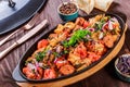 Baked chicken with grilled vegetables, greens, lavash in pan on wooden table. Royalty Free Stock Photo