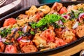 Baked chicken with grilled vegetables, greens, lavash in pan on wooden table. Royalty Free Stock Photo