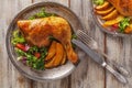 Baked chicken leg, served with roasted potatoes and vegetables Royalty Free Stock Photo