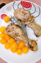 Baked chicken legs with thyme served with yellow cherry tomatoes. Royalty Free Stock Photo