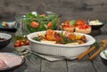 Baked chicken legs on the wooden table with variety food