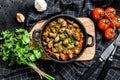 Baked chicken liver hearts in the cast iron pan. Black background. Top view Royalty Free Stock Photo