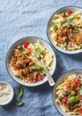 Baked chicken with olives, white wine and sweet peppers and macaroni pasta. Delicious lunch on a blue background Royalty Free Stock Photo