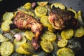 Baked chicken with potatoes, onion and garlic on wooden table