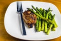Baked chicken thigh served with sauteed asparagus