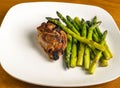 baked chicken thigh served with sauteed asparagus