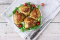 Baked chicken thighs with garnish of arugula and tomatoes. Rustic style, selective focus.