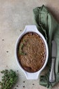 Baked chicken or turkey liver pate or souffle in ceramic mold with thyme stone background. Top view