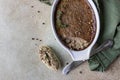 Baked chicken or turkey liver pate or souffle in ceramic mold with thyme, stone background. Top view