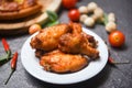 Baked chicken wing bbq grill on plate - hot and spicy chicken and sauce on dark background Royalty Free Stock Photo