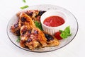 Baked chicken wings in the Asian style and tomatoes sauce on plate Royalty Free Stock Photo