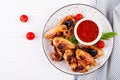 Baked chicken wings in the Asian style and tomatoes sauce on plate. Royalty Free Stock Photo